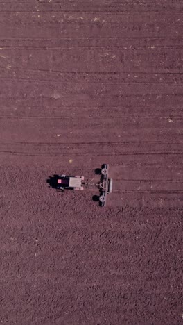 shooting from drone flying over tractor with harrow system
