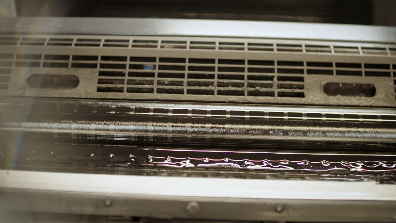 rodillo con color más oscuro girando en la máquina de impresión, color brillante en la luz