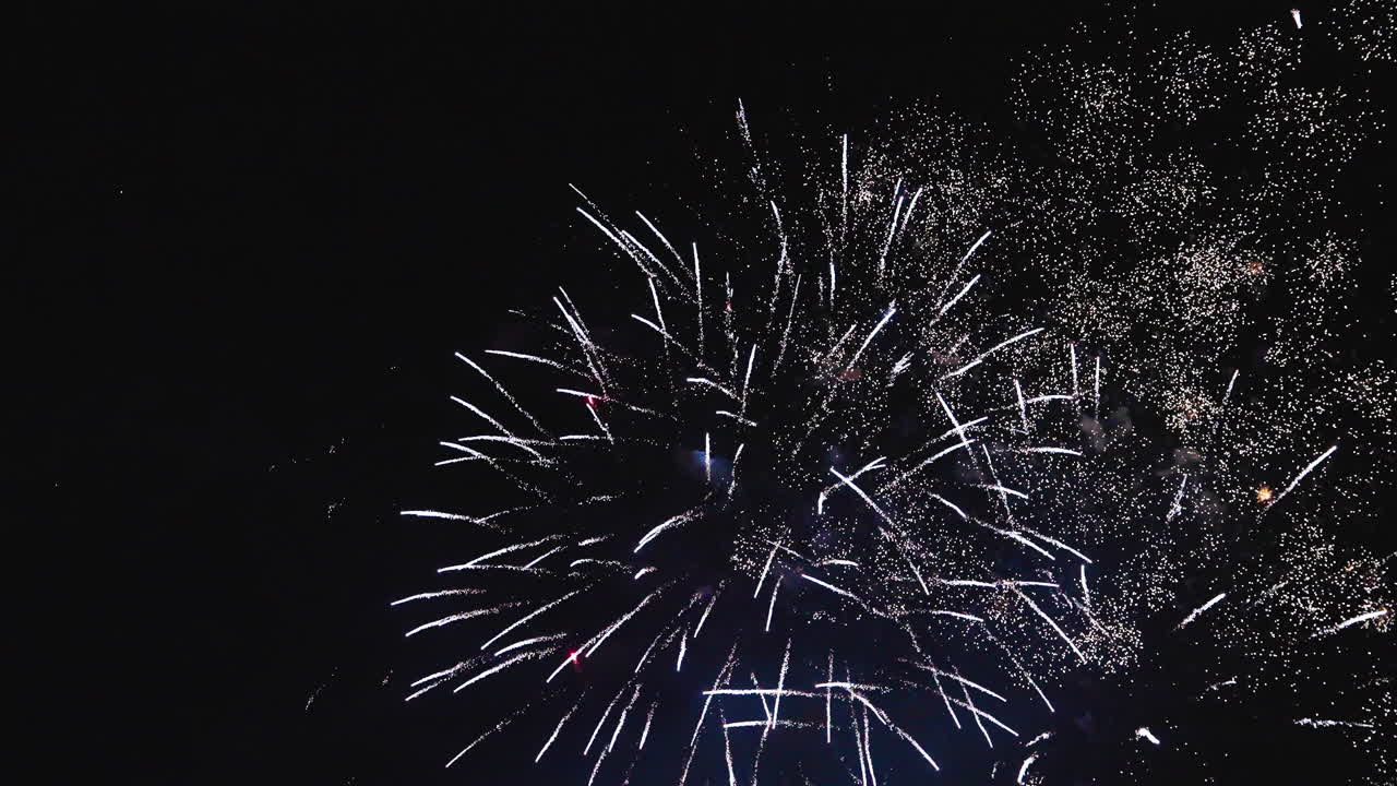 Panoramic fireworks show spreading colorful bursts across night sky