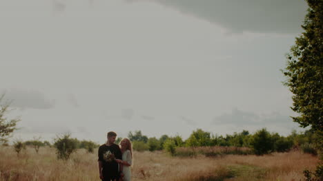 Young-Man-Supporting-Woman-Outdoors-In-Summer-1