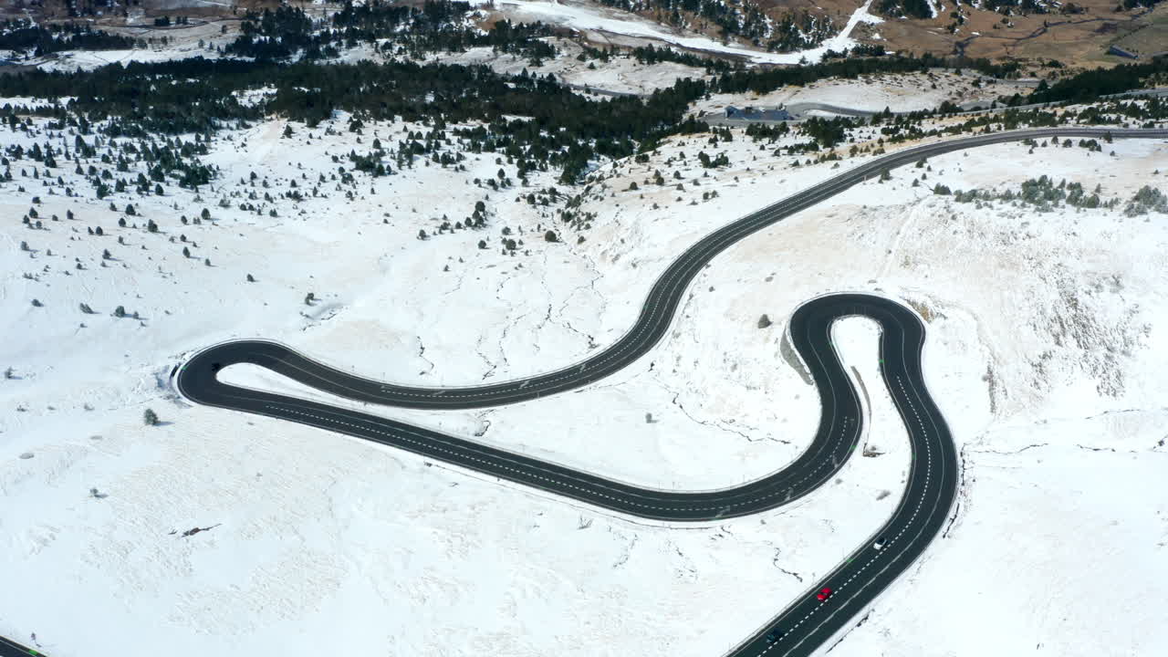 Top-down drone shot of a snowy road in Andorra, near the border with France