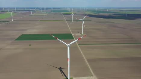 aerial view of several windmills, wind generators, turbines, producing renewable clean energy by converting kinetic energy