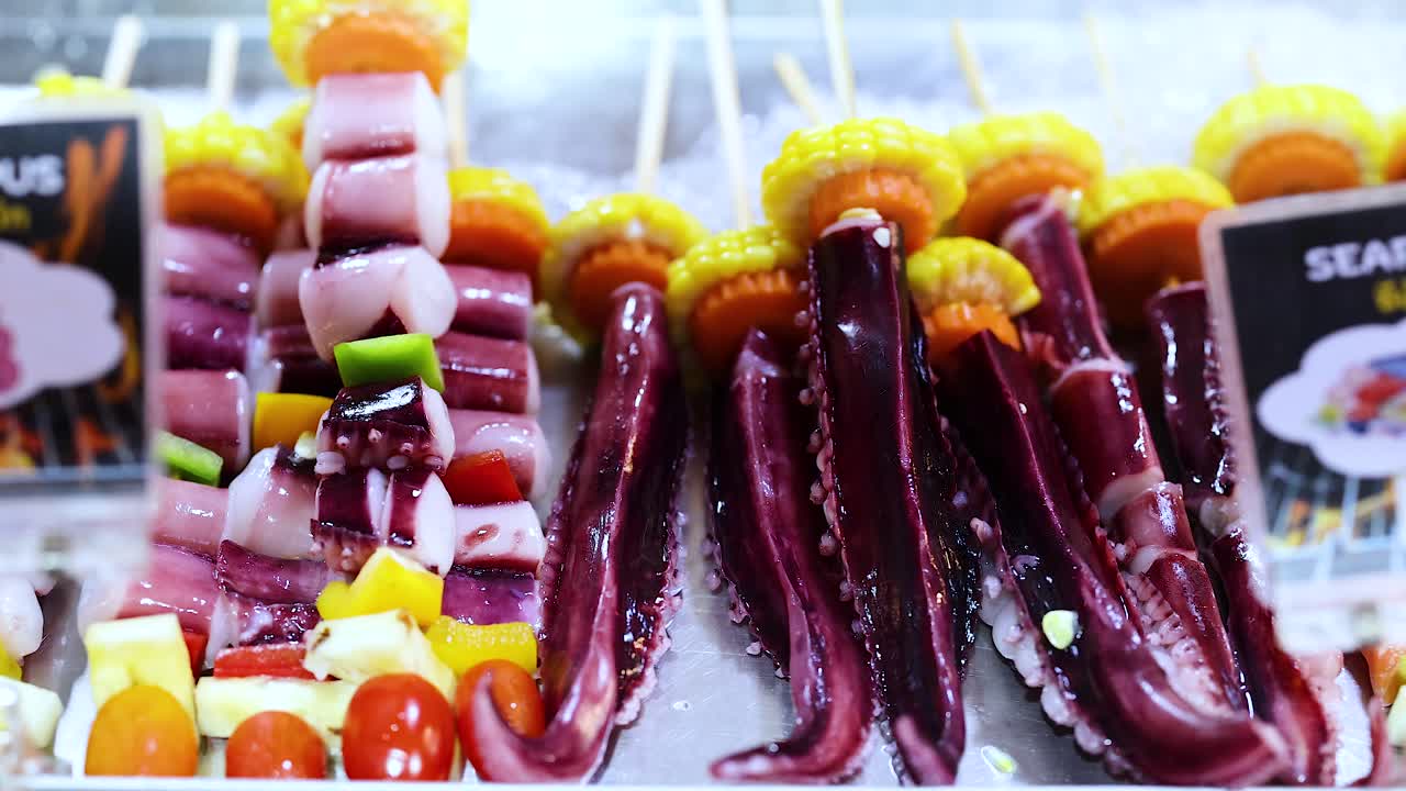 Colorful seafood skewers on ice at night market