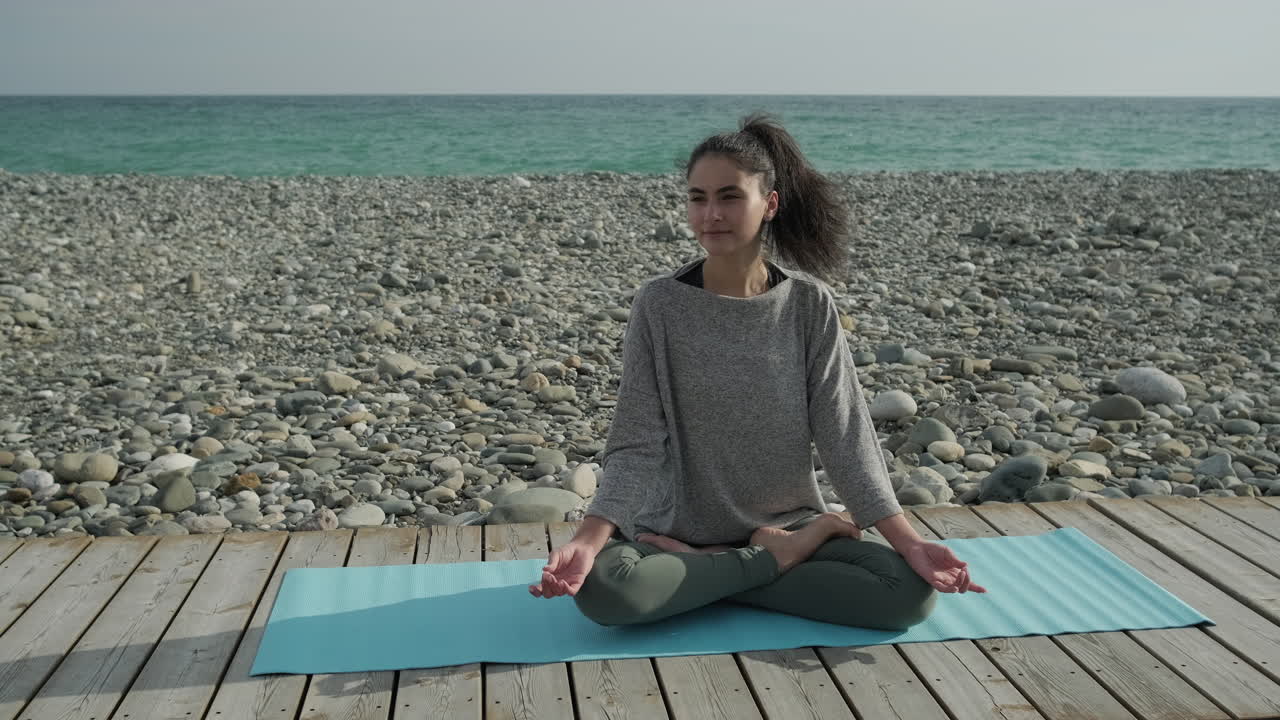 mujer practicando yoga en la playa