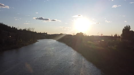 descending sunset drone flies above the arno river. girone small town near fiesole florence, in the tuscany region of italy. december 2019
