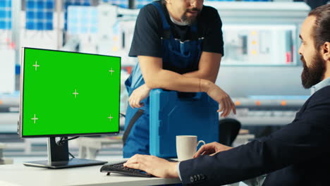 el gerente de la fábrica de fotovoltaica hablando con un empleado, usando una computadora de pantalla verde