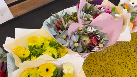vibrant flower bouquets displayed on a counter with bright lighting, showcasing diverse floral arrangements in a florist shop
