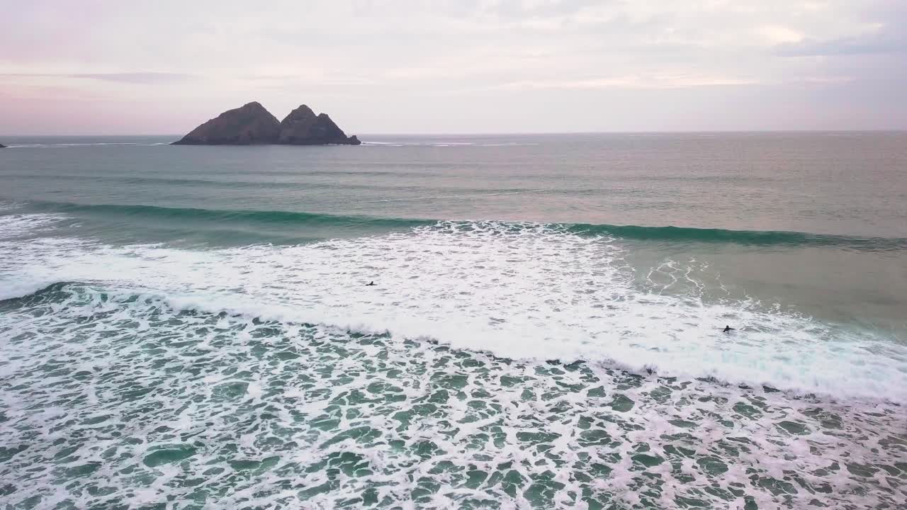 부서지는 파도를 뚫고 바다로 나가는 서퍼들