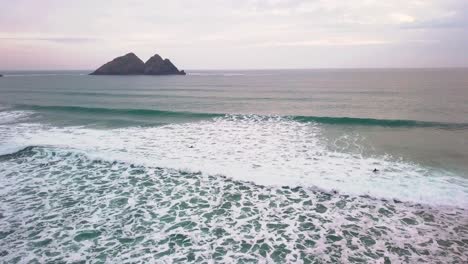 surfers duck-diving their way out to sea through crashing waves