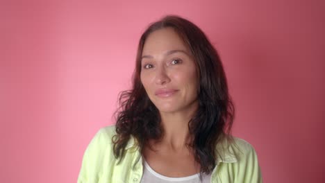 woman smiling in front of pink background