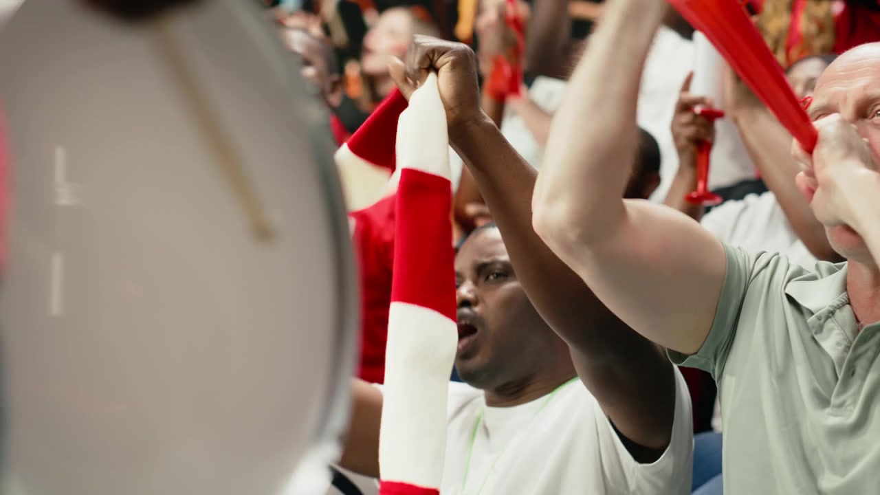 Primo piano di un leader di gruppo di tifosi che batte i tamburi e guida i cori