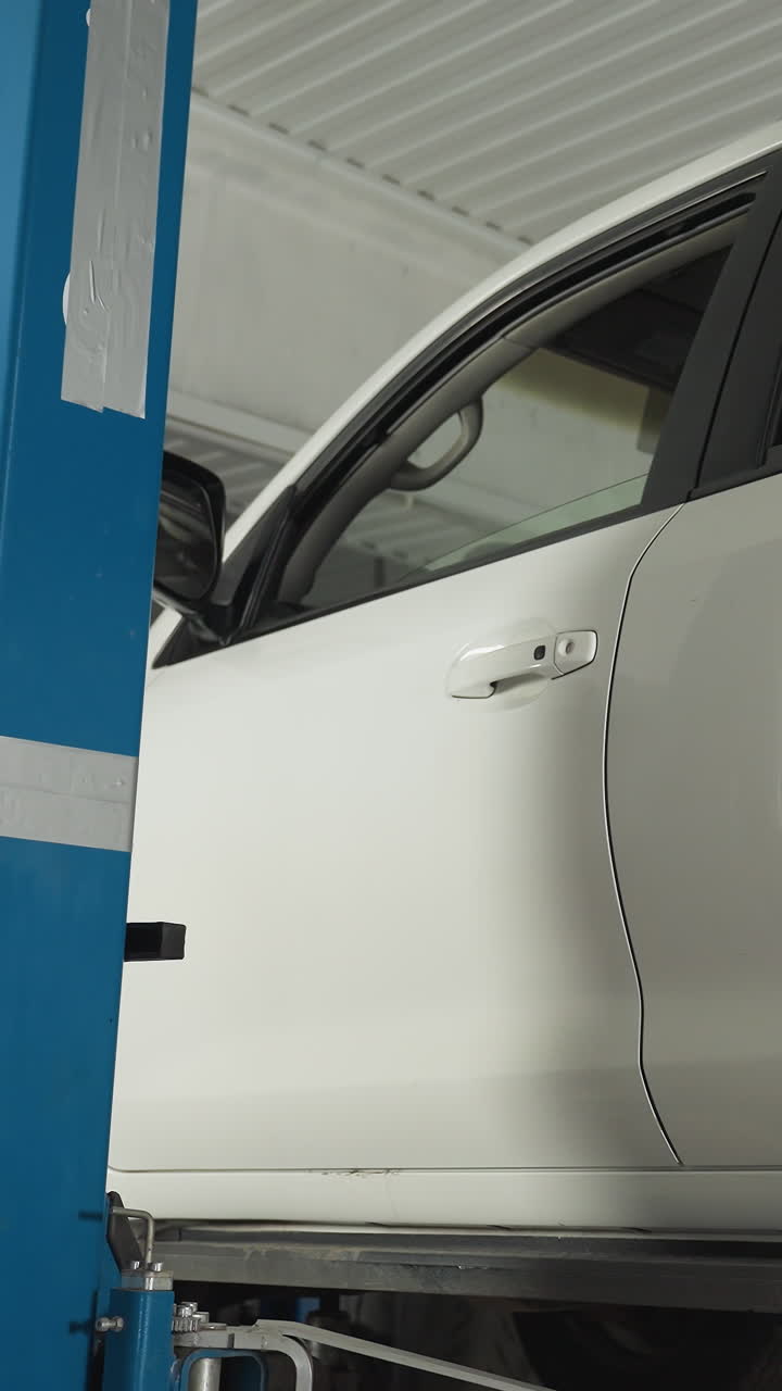 차량 유지 보수 프로세스를 보여주는 깨하고 조직 된 자동차 수리점 내의 수압 엘리베이터에서 조심스럽게 내려지는  suv