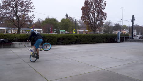 guy riding a bmx bike in a skatepark,doing spinning and balance tricks