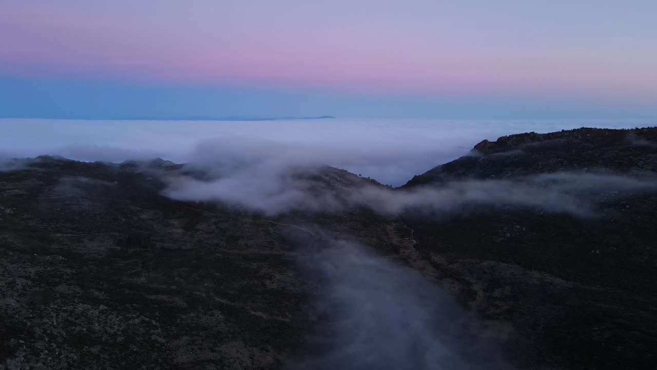 Aerial view of a beautiful foggy rocky mountain valley