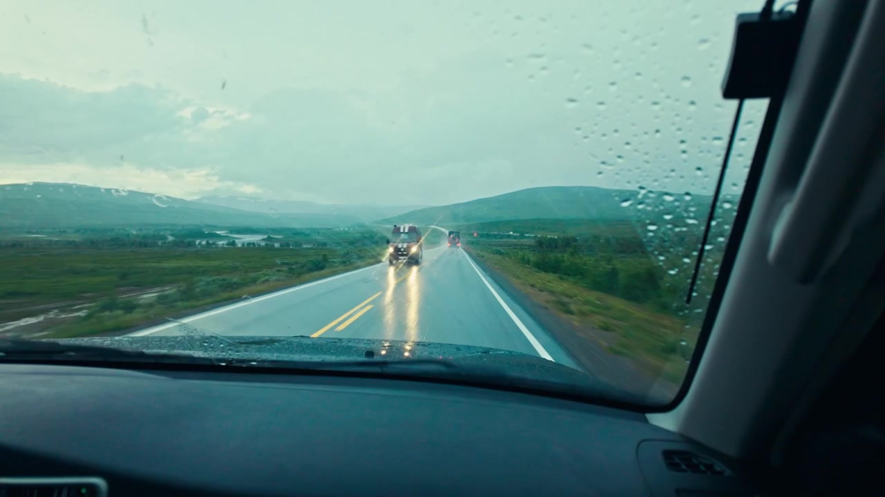 POV dall'interno di un veicolo che attraversa un paesaggio montuoso panoramico in Norvegia in una giornata piovosa