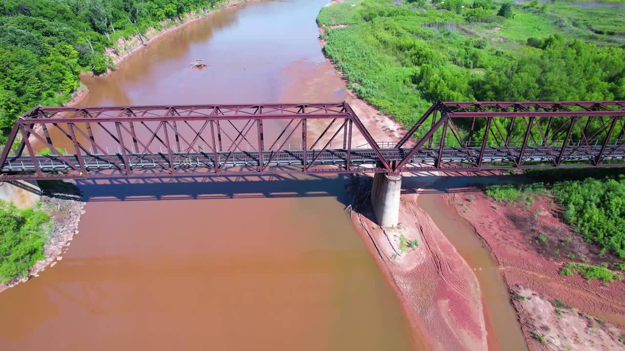 imágenes aéreas volando sobre un puente de tren en el río rojo en texas