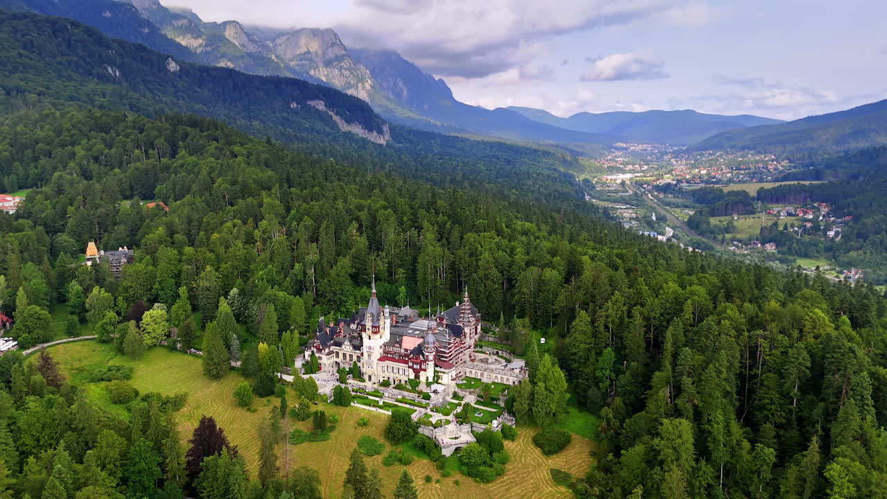 Stunning Peles Castle surrounded by the pine tree woods in the Carpathians, Romania. Drone footage. Sinaia scenery at backdrop