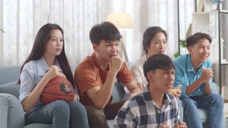 asian teenagers cheering and watching basketball game on smart phone. team celebrating victory and team disappointed