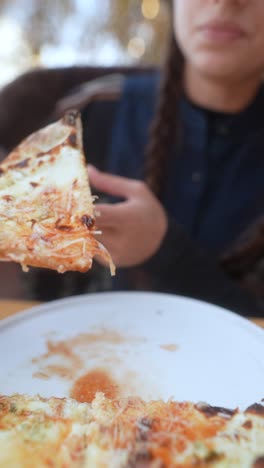 persona comiendo una rebanada de pizza