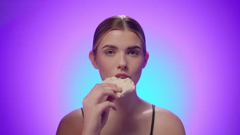 sporty fitness woman enjoys a white natural rice cake, concept eating sport food