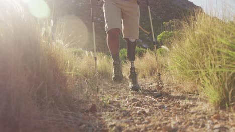 low section of mixed race man with prosthetic leg hiking in nature