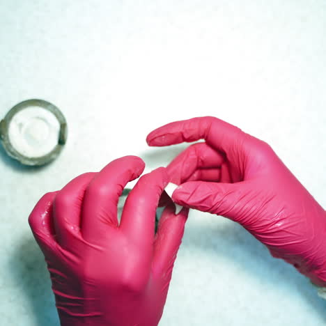 manufacturing eye prosthesis. doctor's hands making plastic eye prosthesis clean. ready artificial eye in hands of a technician.