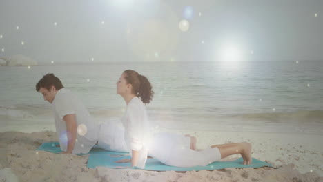 people practicing yoga on beach over glowing light particles animation