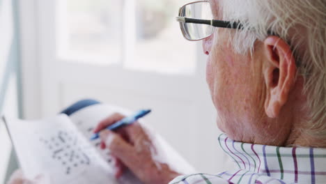 Senior-man-doing--crossword,-close-up