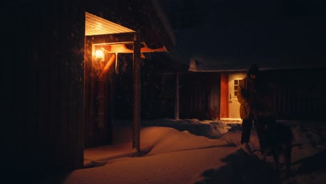 man with his pet dog walking outside the winter village at night