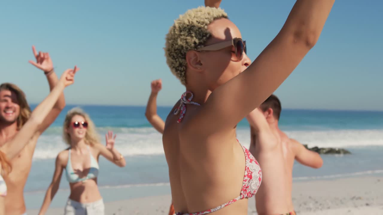 Young adult friends dancing at the beach 4k