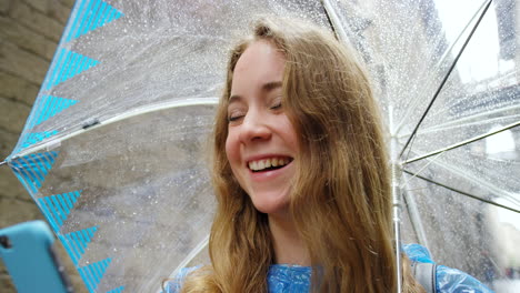 teenager using phone under umbrella in the rain