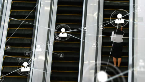 animación de la red de iconos de perfil sobre la vista trasera de la mujer de negocios en la escalera mecánica en la oficina moderna.