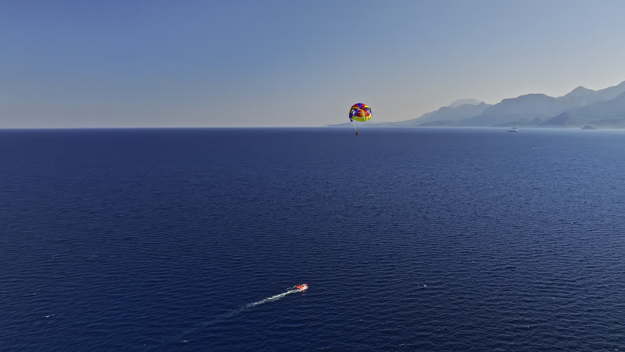 antalya turquía antena v10 drone sobrevuelo capturando parasail volando alto en el cielo sobre azul profundo ver con vistas al paisaje urbano costero y montañoso de muratpaşa - filmado con cine mavic 3 - julio de 2022