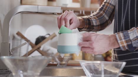 hands of caucasian man washing dishes in kitchen, slow motion