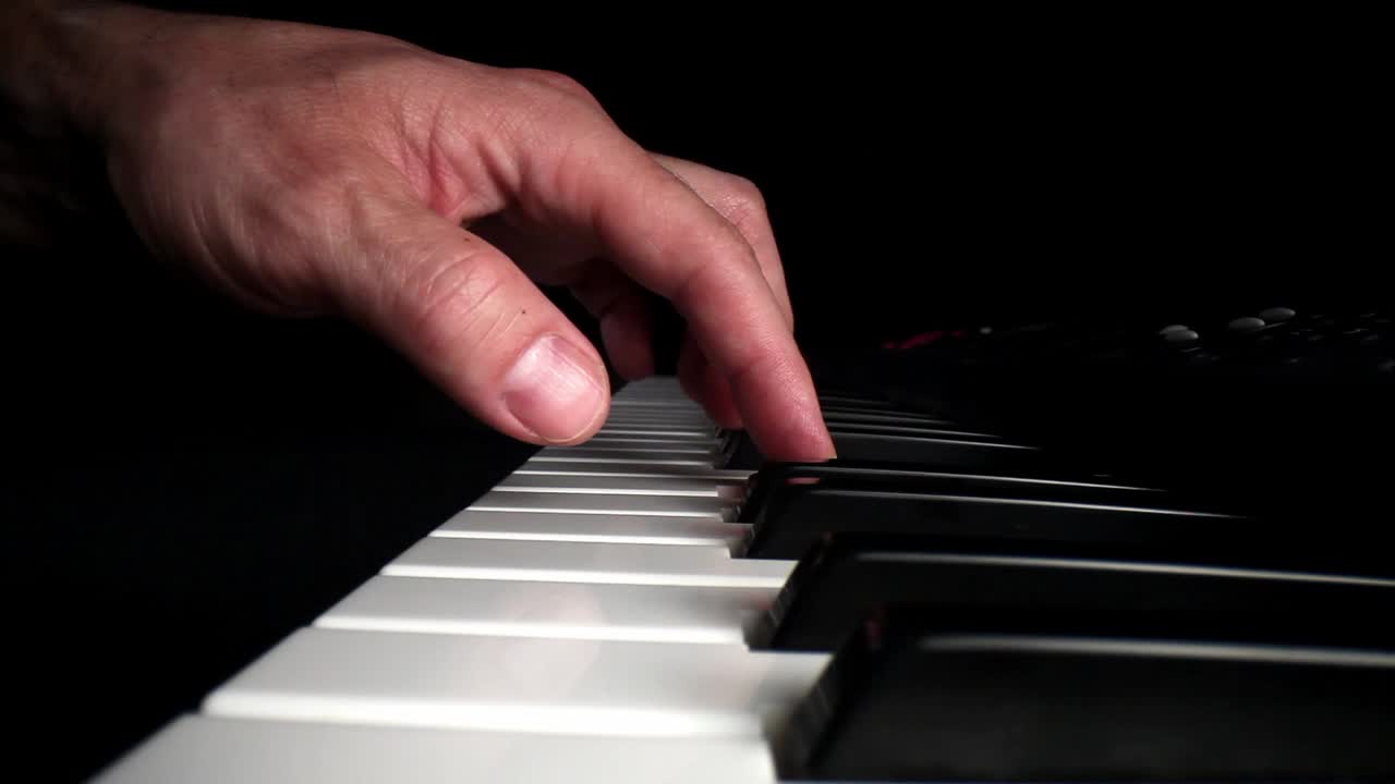 alejándose lentamente de la persona que toca el teclado electrónico con la mano izquierda