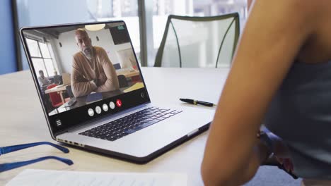 Mujer-Afroamericana-Usando-Una-Computadora-Portátil-Para-Videollamadas,-Con-Un-Colega-De-Negocios-En-La-Pantalla