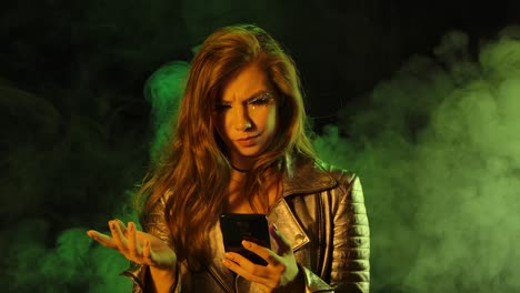 mujer usando un teléfono inteligente en un estudio ahumado