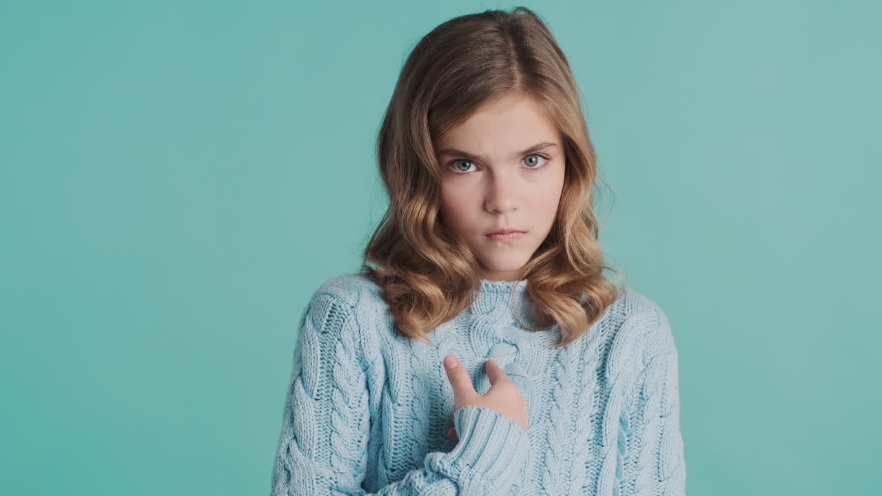 카메라 앞에서 손가락을 가리키는 충격적인 십대 백인 소녀.