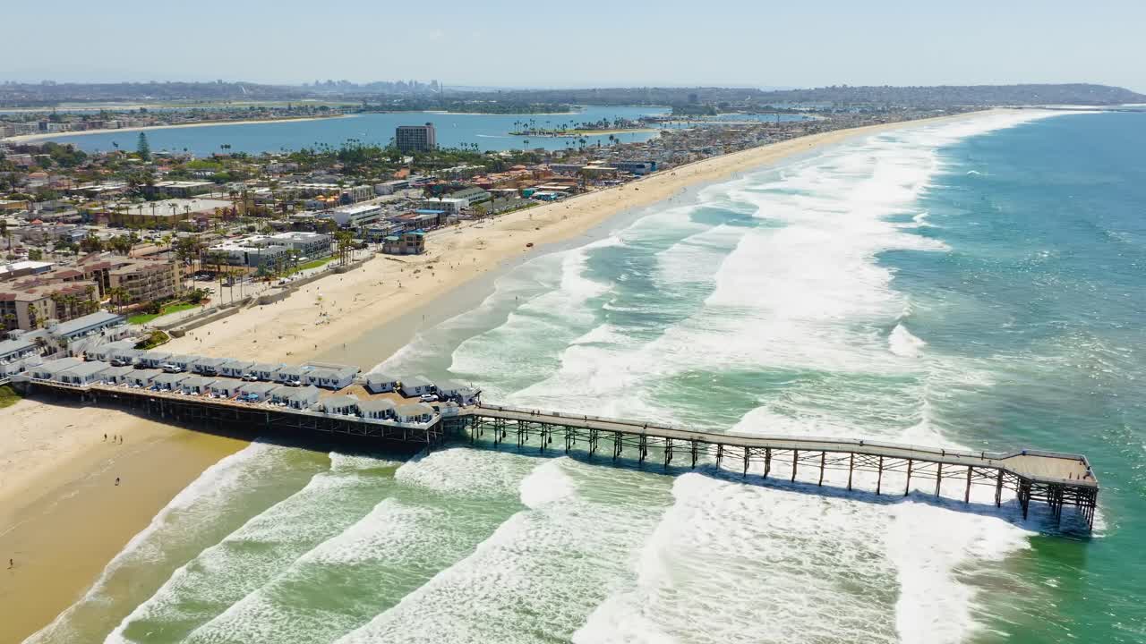 Aerial captivating time-lapse over Pacific Beach, showcasing the vibrant coastline as waves roll onto the sandy shore