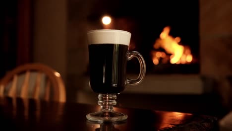 irish coffee on a table with a fire in the background