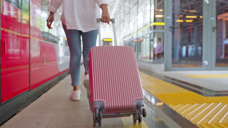 woman walking with suitcase at train station