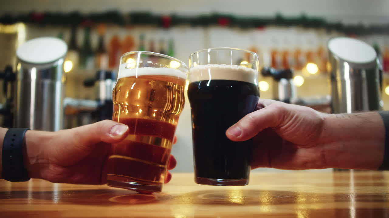 Due mani che brindano con bicchieri di birra in un bar