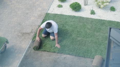 jardinero colocando un rollo de césped natural
