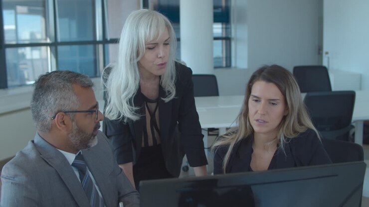 Leader watching and discussing presentation with her team