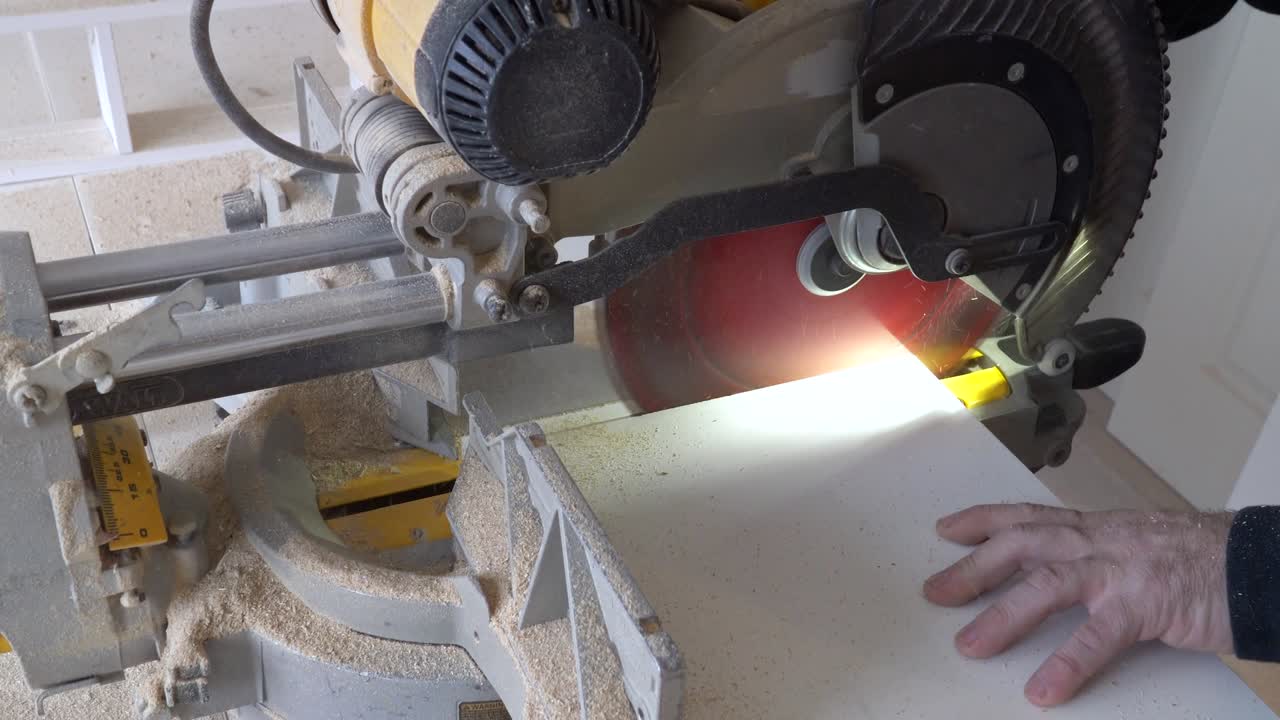 건설 작업자: 스라이더 컴파운드 미터 사 또는 원형 사를 사용하여 거대한 목재 보드를 절단합니다. 건설, 리모델링 작업의 세부 사항