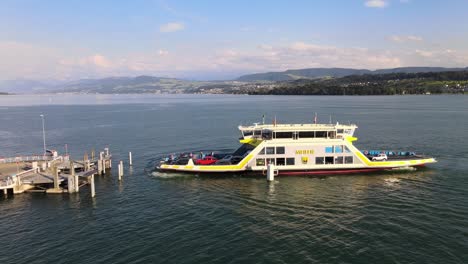 aerial drone side shot of car ferry meilen arriving at meilen on lake zürich in switzerland