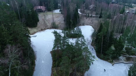 Patinaje-Sobre-Hielo-En-Un-Estanque-Helado,-Un-Río-O-Un-Parque-Público-Inundado---Revelación-Aérea-Inclinada-Hacia-Arriba