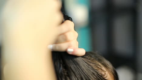 young woman having her hair dyed by beautician at parlor