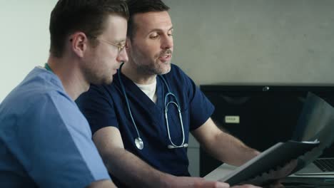 two male caucasian doctors discussing over medical x-ray scan