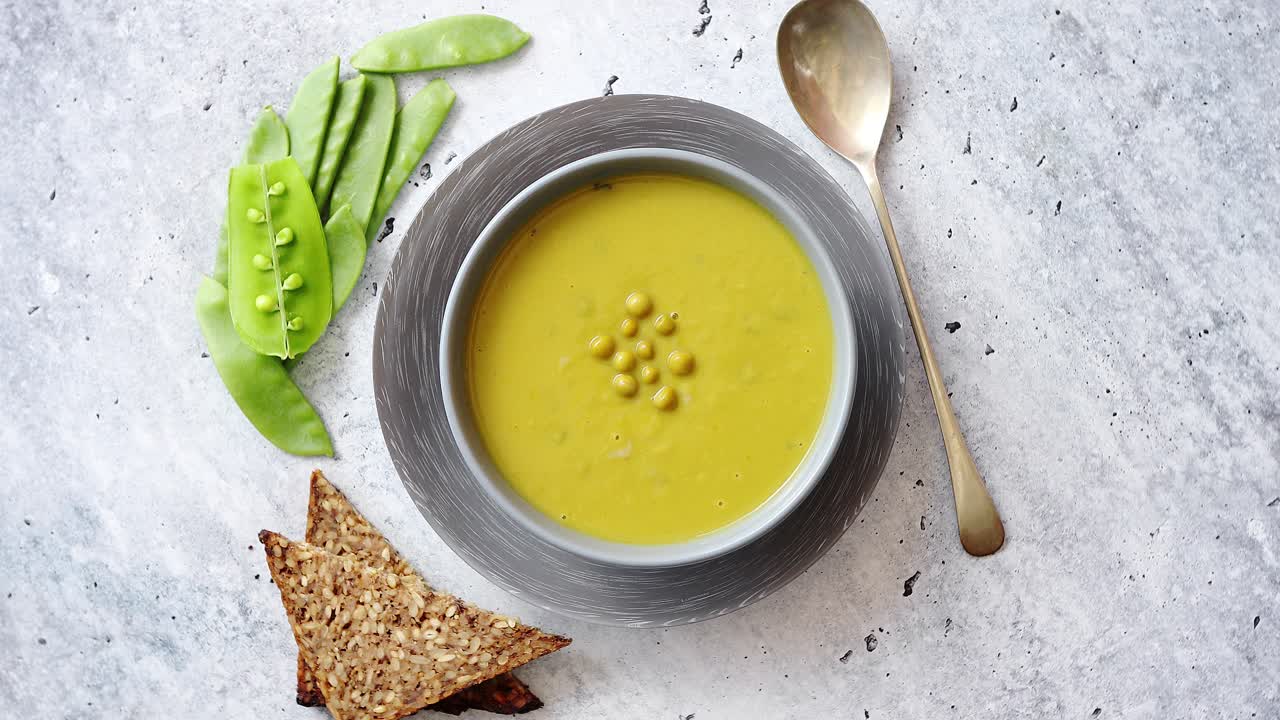 grønn ærteskremsoppe i grå skål